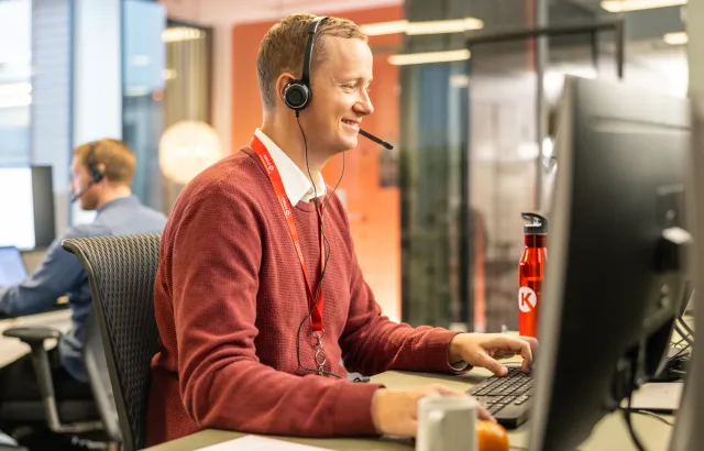 Happy and helpful Circle K customer service employee working at his desk